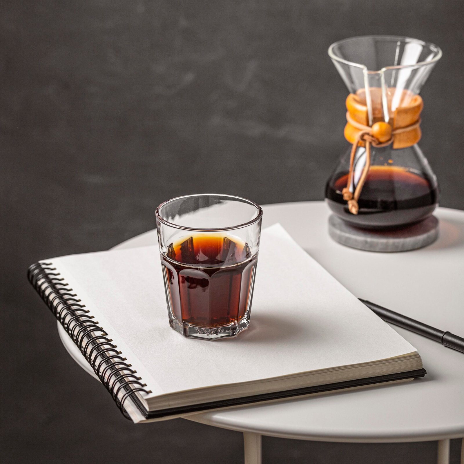 high-angle-glass-coffee-with-notebook-pen